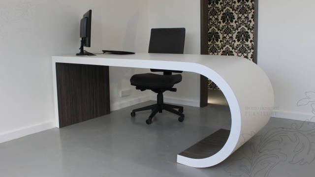 Large J shaped office desk with computer and chair